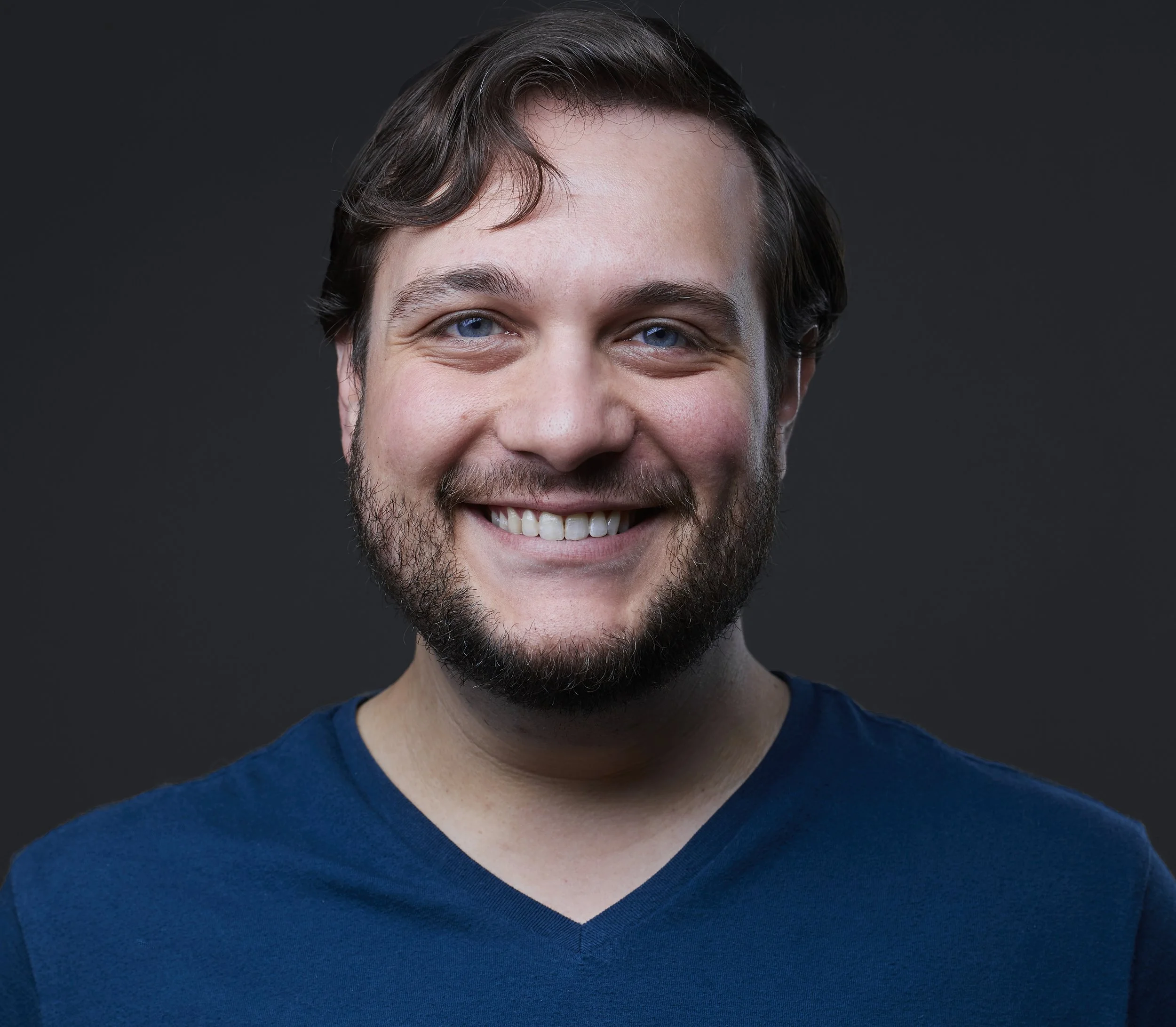 Headshot of an actor wearing a blue T-shirt