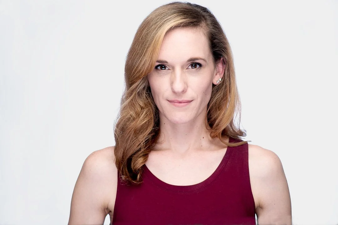 Female acress wearing a red shirt photographed against a white backdrop