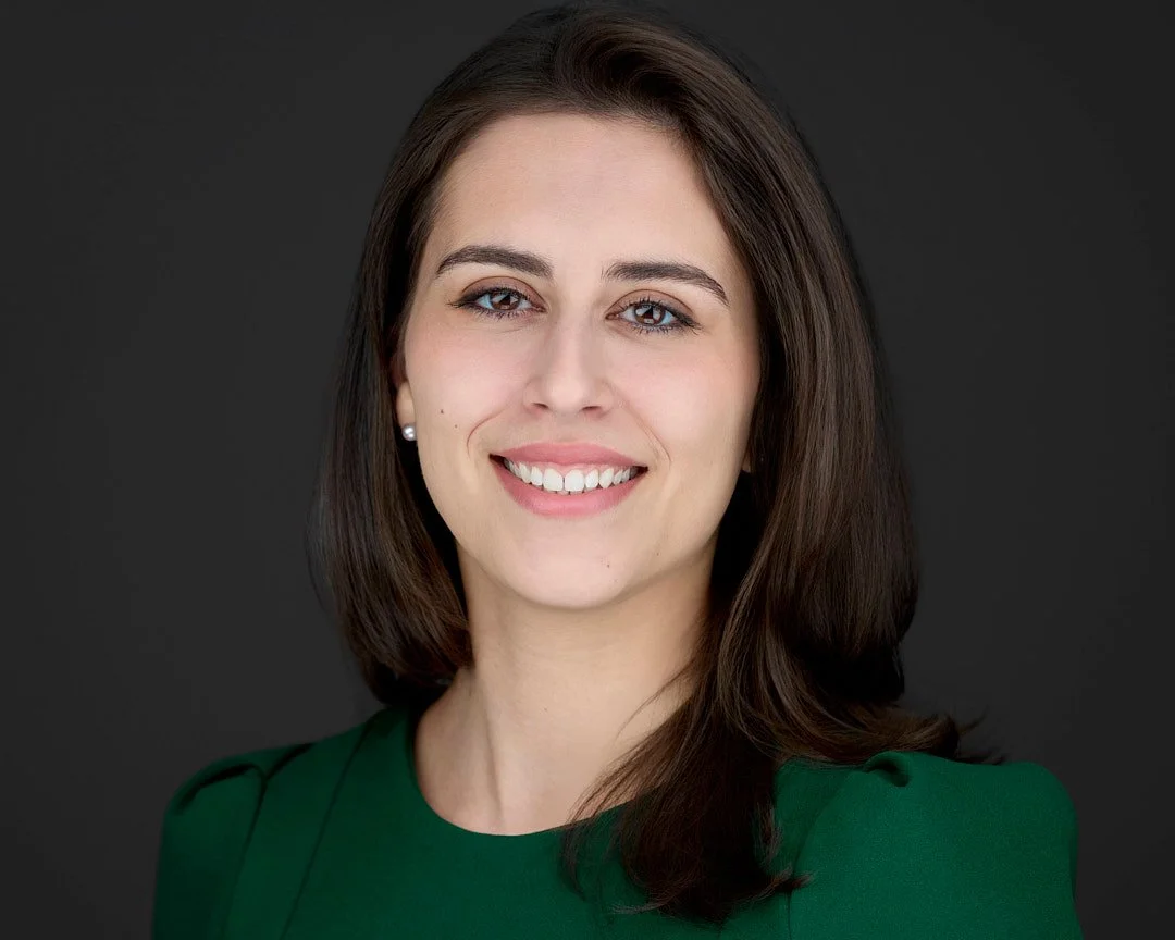 Headshot for linkedin of a woman with brown hair wearing a green dress