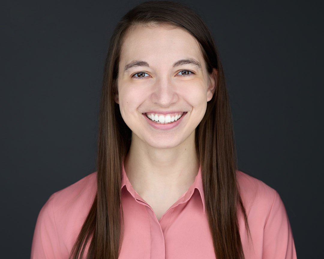 Headshot of a young woman wearing a salmon colored shirt for her ERAS headshot