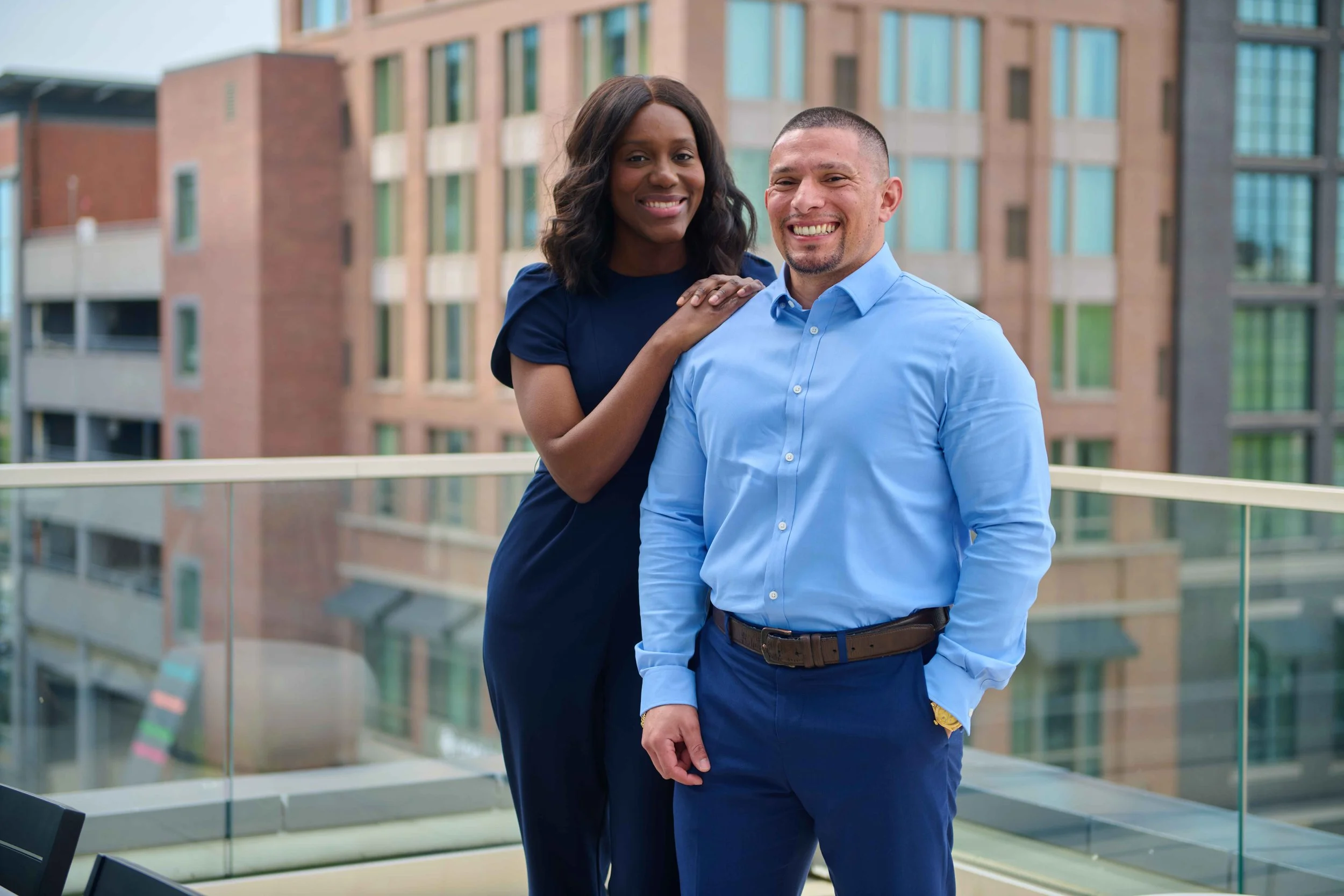 Branding portrait of a husband and wife team on a rooftop deck