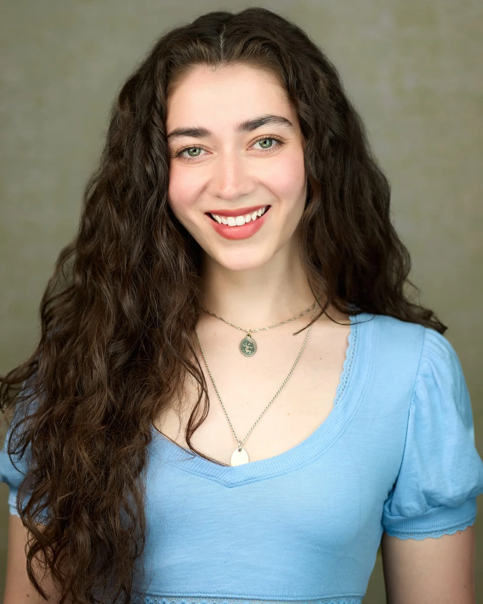 Professional Acting headshot of a female wearing a blue shirt with long brown hair