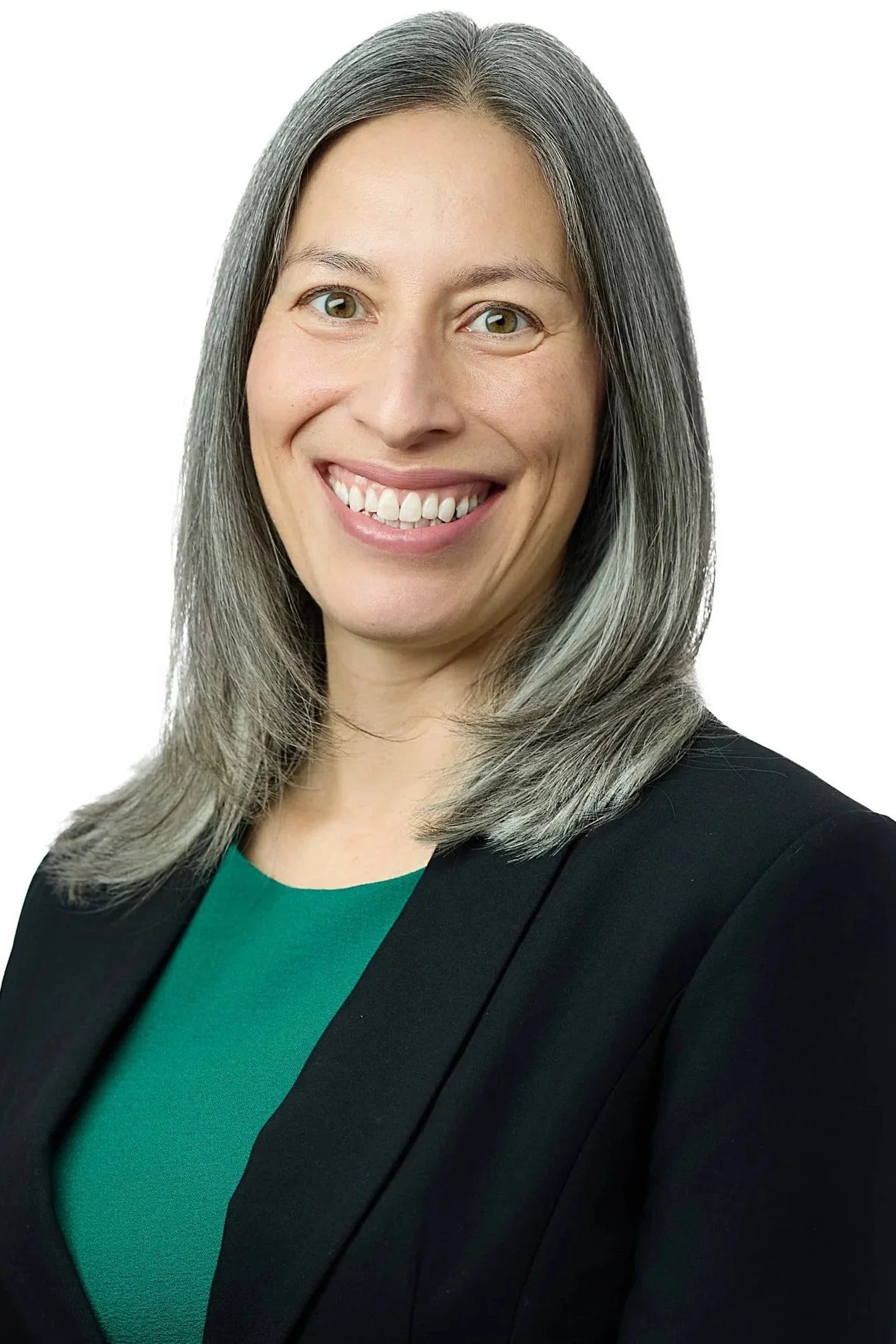 Headshot of a woman wearing a green dress and black jacket