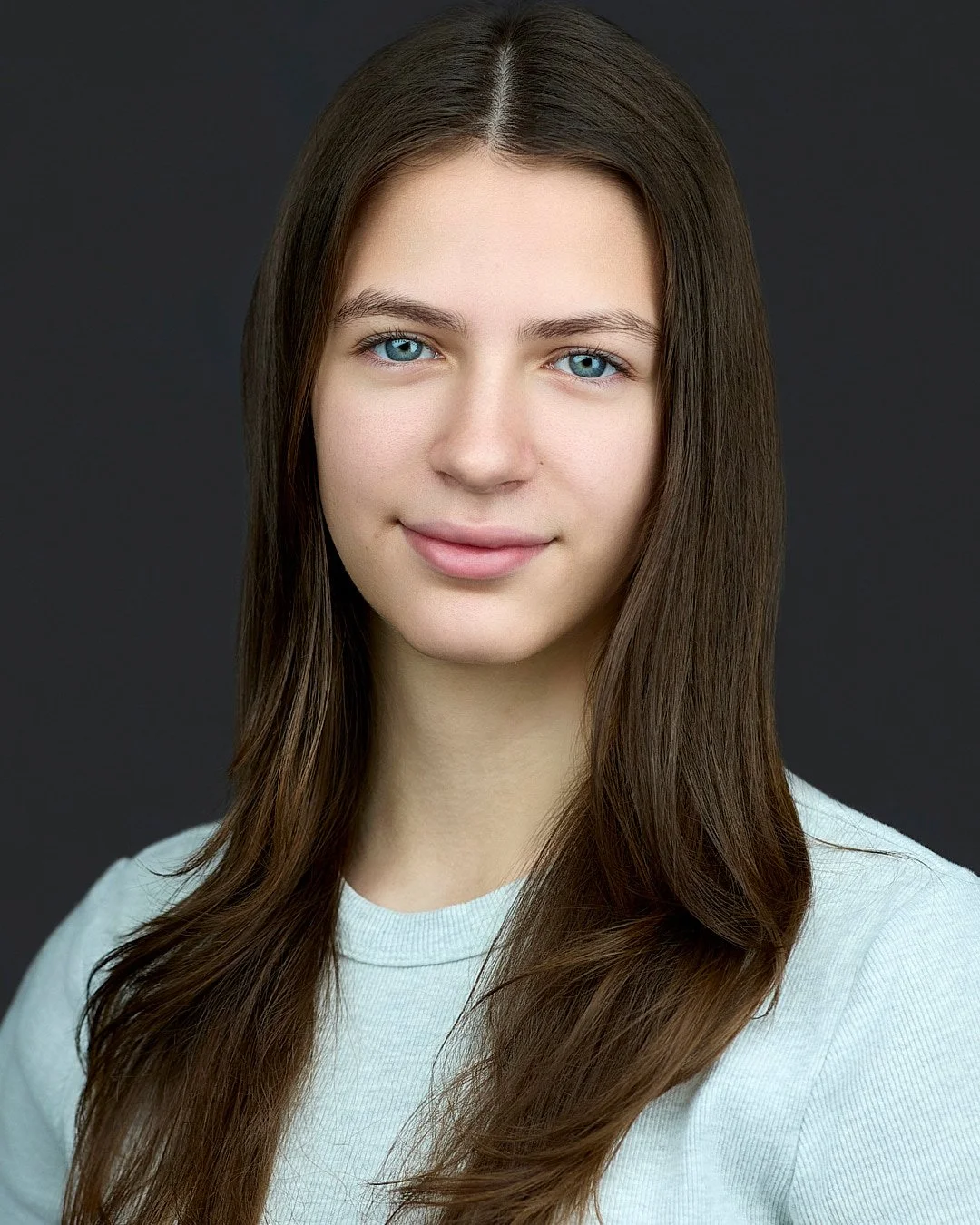 Theater headshot of a young woman wearing a light blue shit