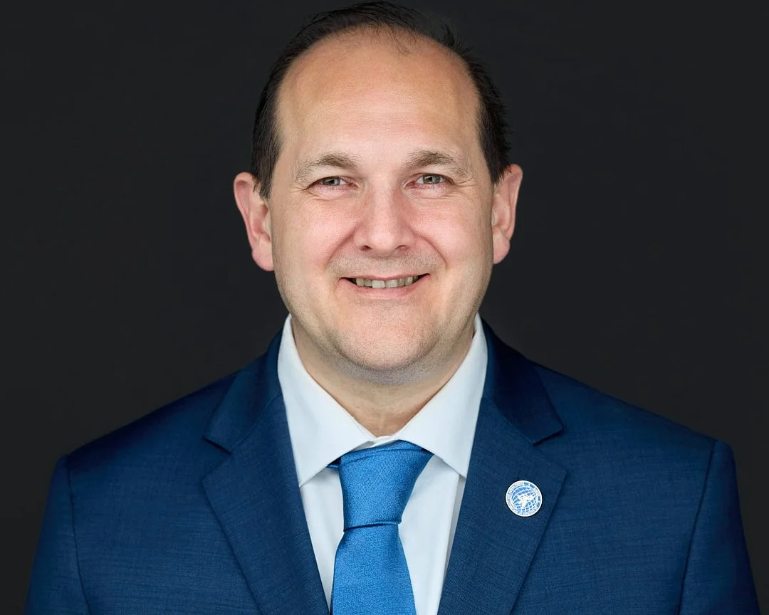 Professional Aerospace headshot of a man wearing a blue suit and tie