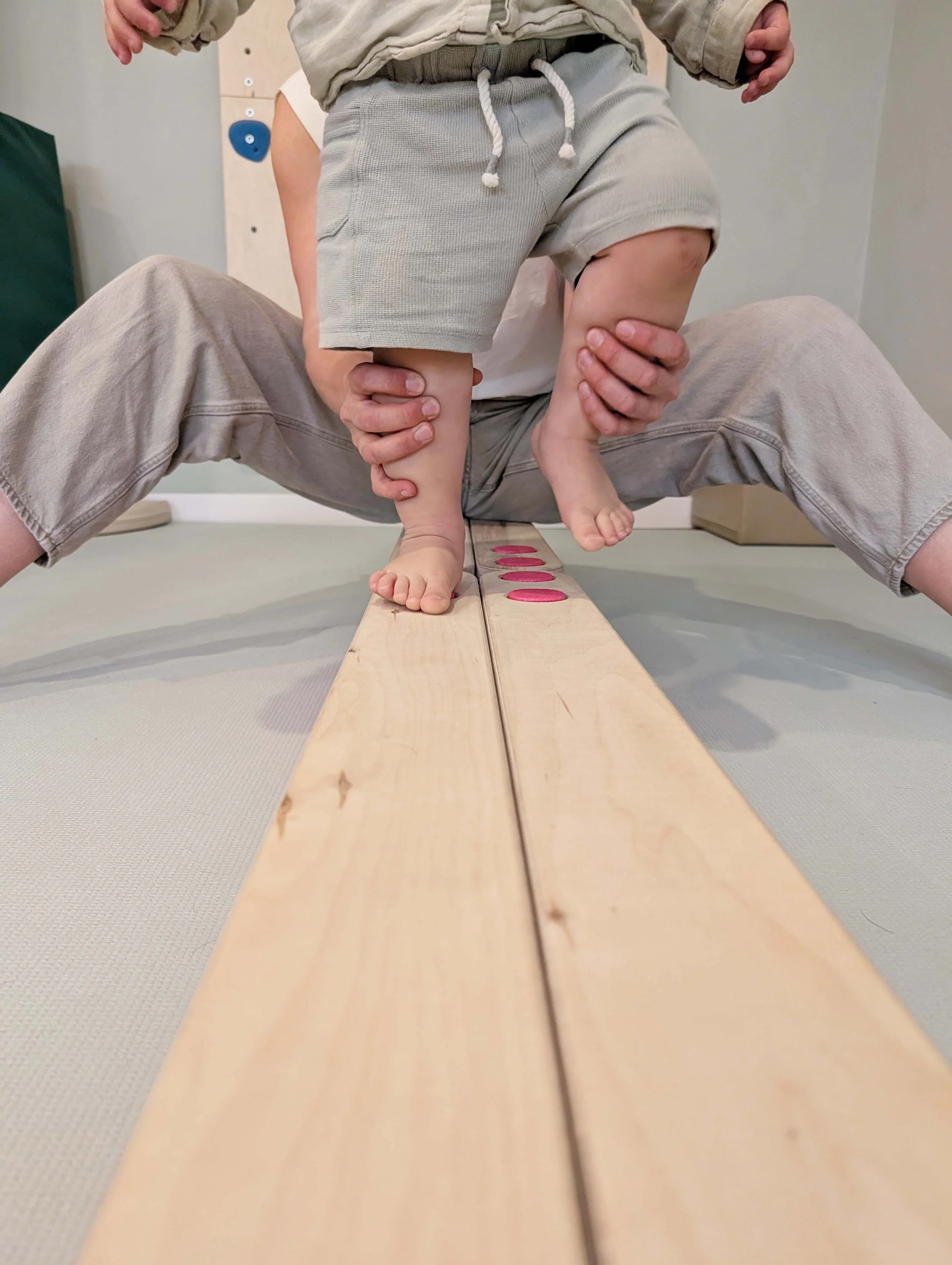Erwachsene Hände halten die Beine eines Kleinkindes. Man bekommt einen Einblick in eine physiotherapeutische Trainingseinheit bei Kindern. Foto: Leandra Busch