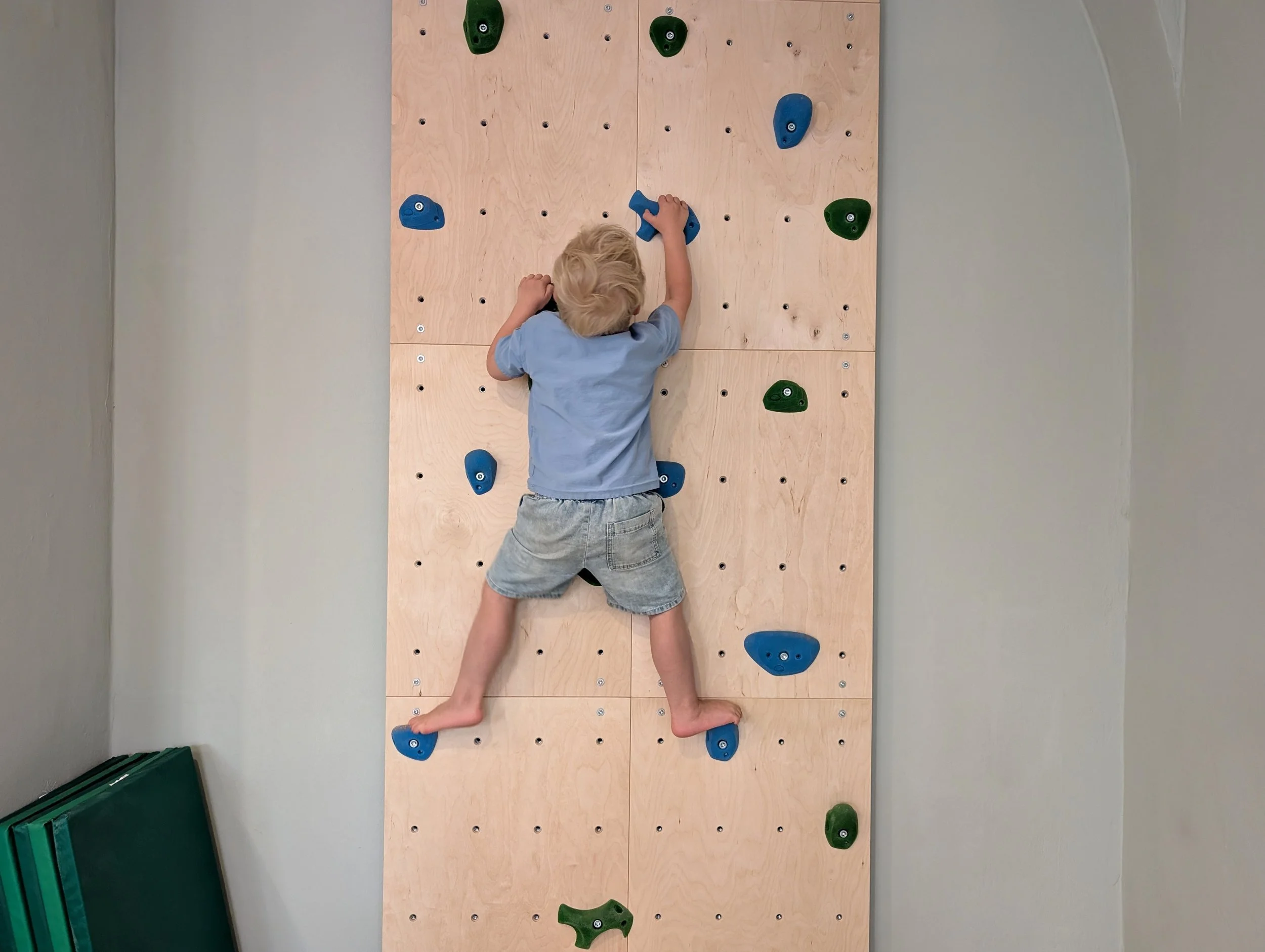 Ein Kleinkind klettert eine Kletterwand hinauf. Physiotherapie für Kinder - Anne Tandler - Fritzi - Neuötting - Bayern - Nähe München -Foto: Leandra Busch