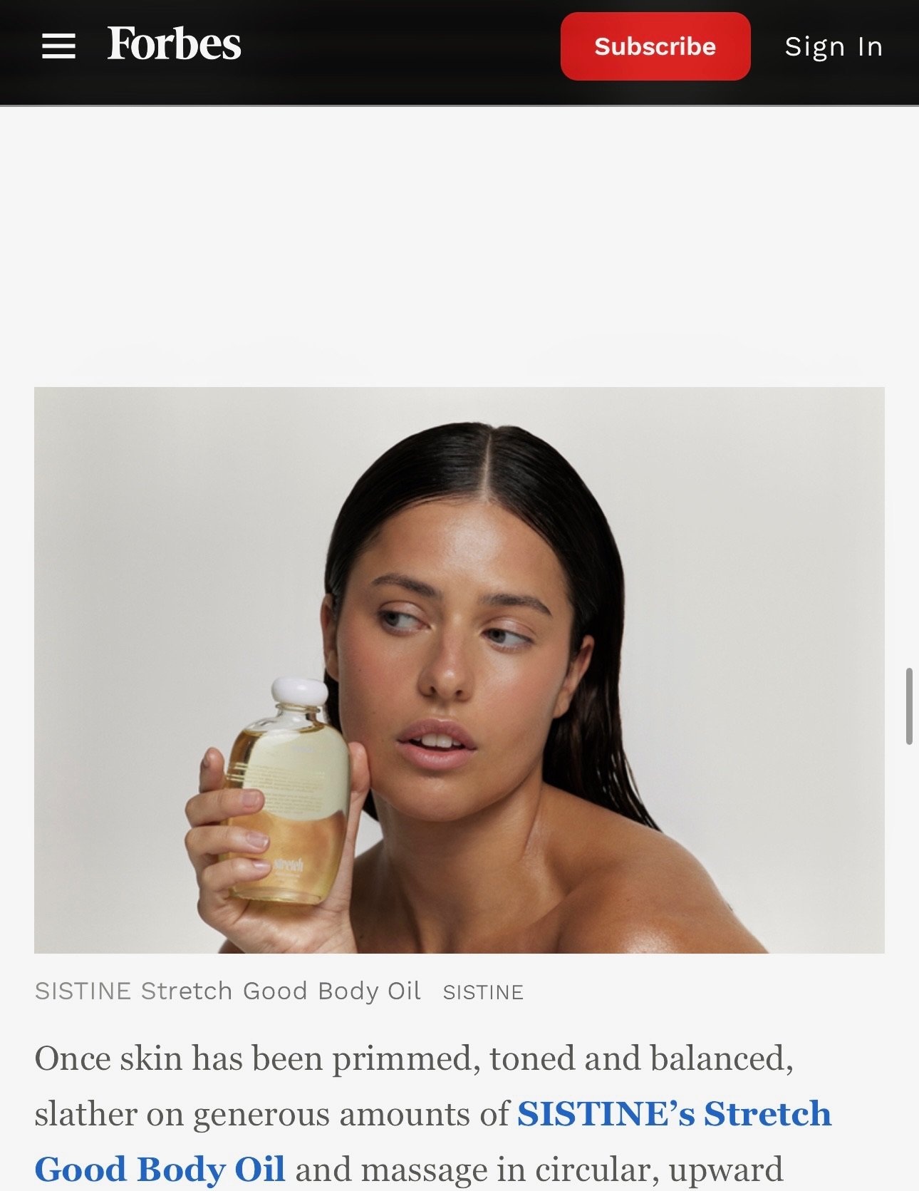 A woman in a Vogue Article with dark, wet hair holding a clear bottle of SISTINE Stretch Good Body Oil, looking to her left with a neutral expression against a plain white background.