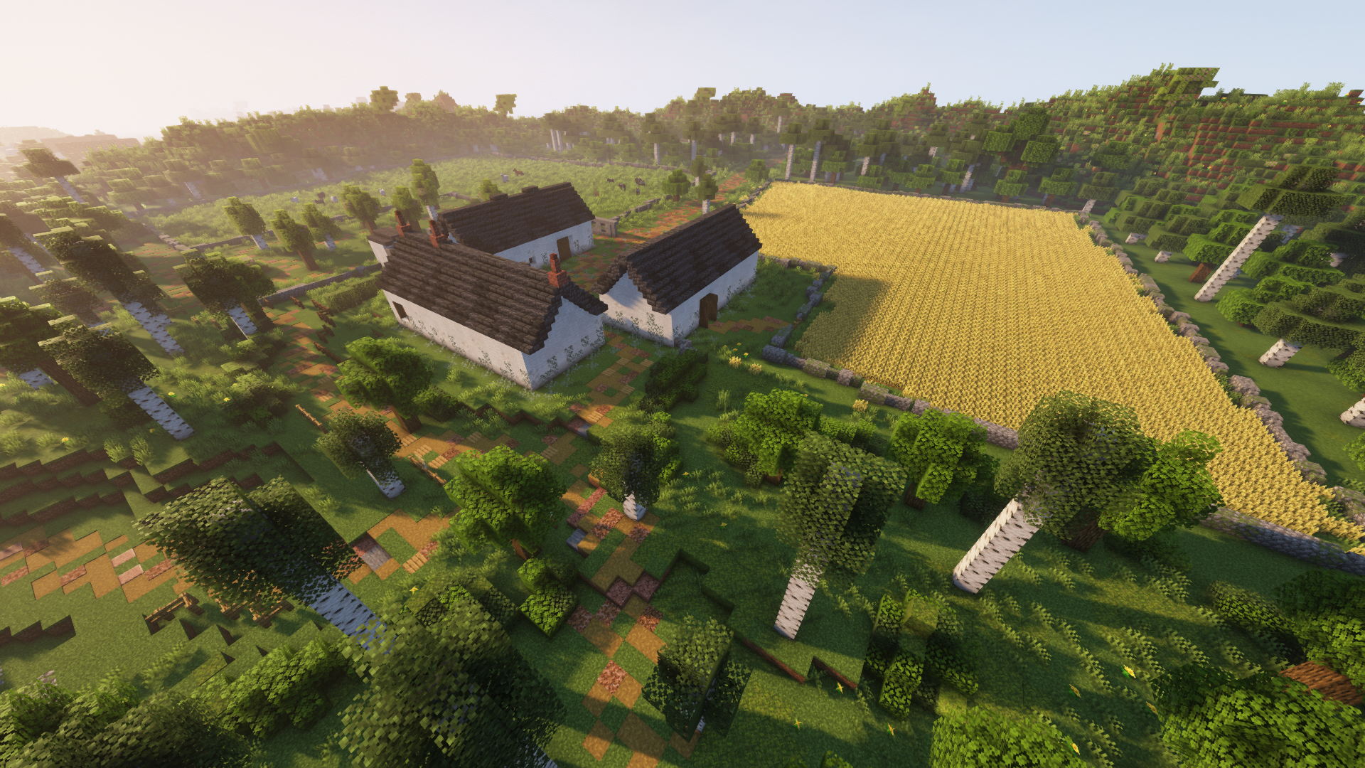 A Minecraft scene showing a farm with three white cottages, a large wheat field, and surrounding green trees, with sunlight filtering through.