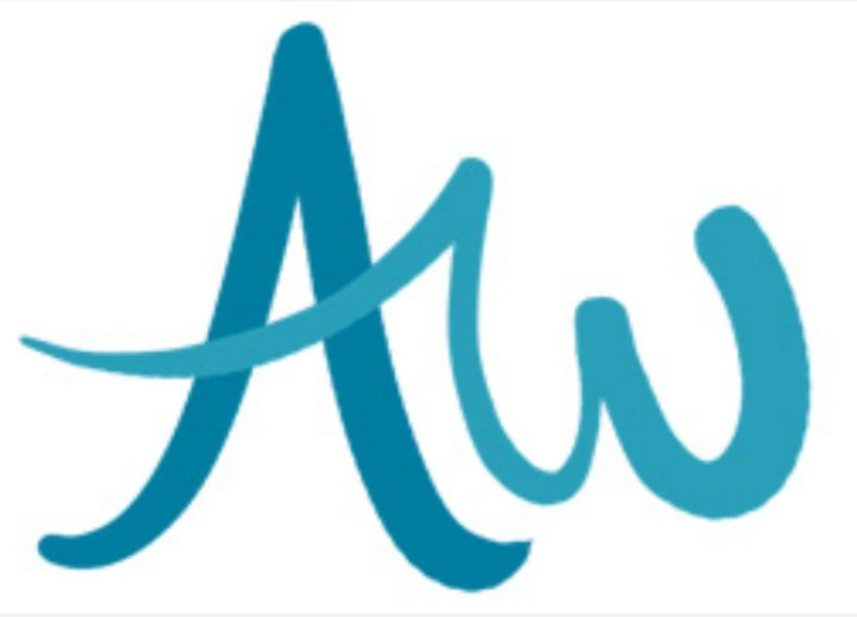 A woman with blonde hair sitting on a white couch, smiling, with a brown and white dog resting on her lap. The background is a bright, airy room with white curtains.