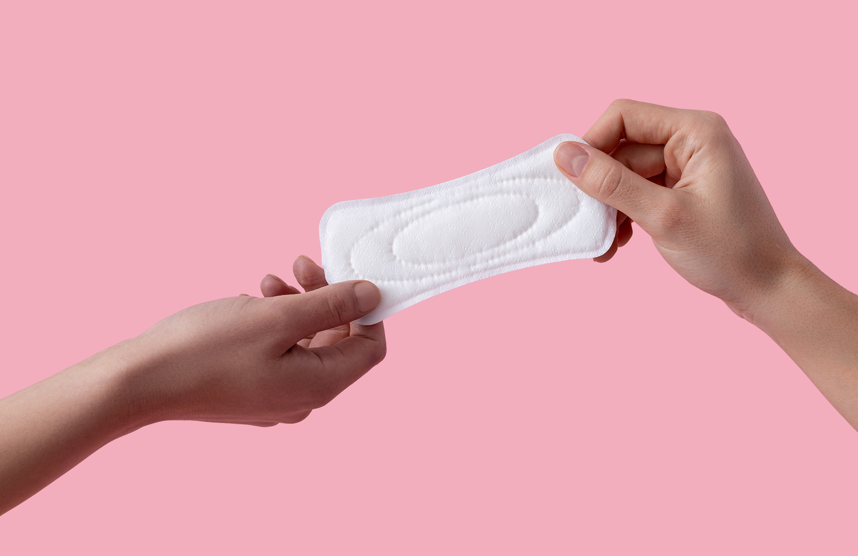 Two hands holding a white sanitary pad against a pink background.