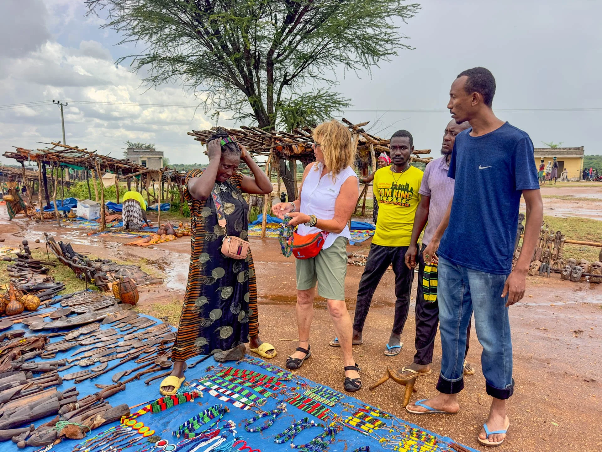 Caravan Gallery in La Conner, WA - Owner Linda negotiating in Ethiopia at outdoor market with handcrafted jewelry and artifacts in Africa.