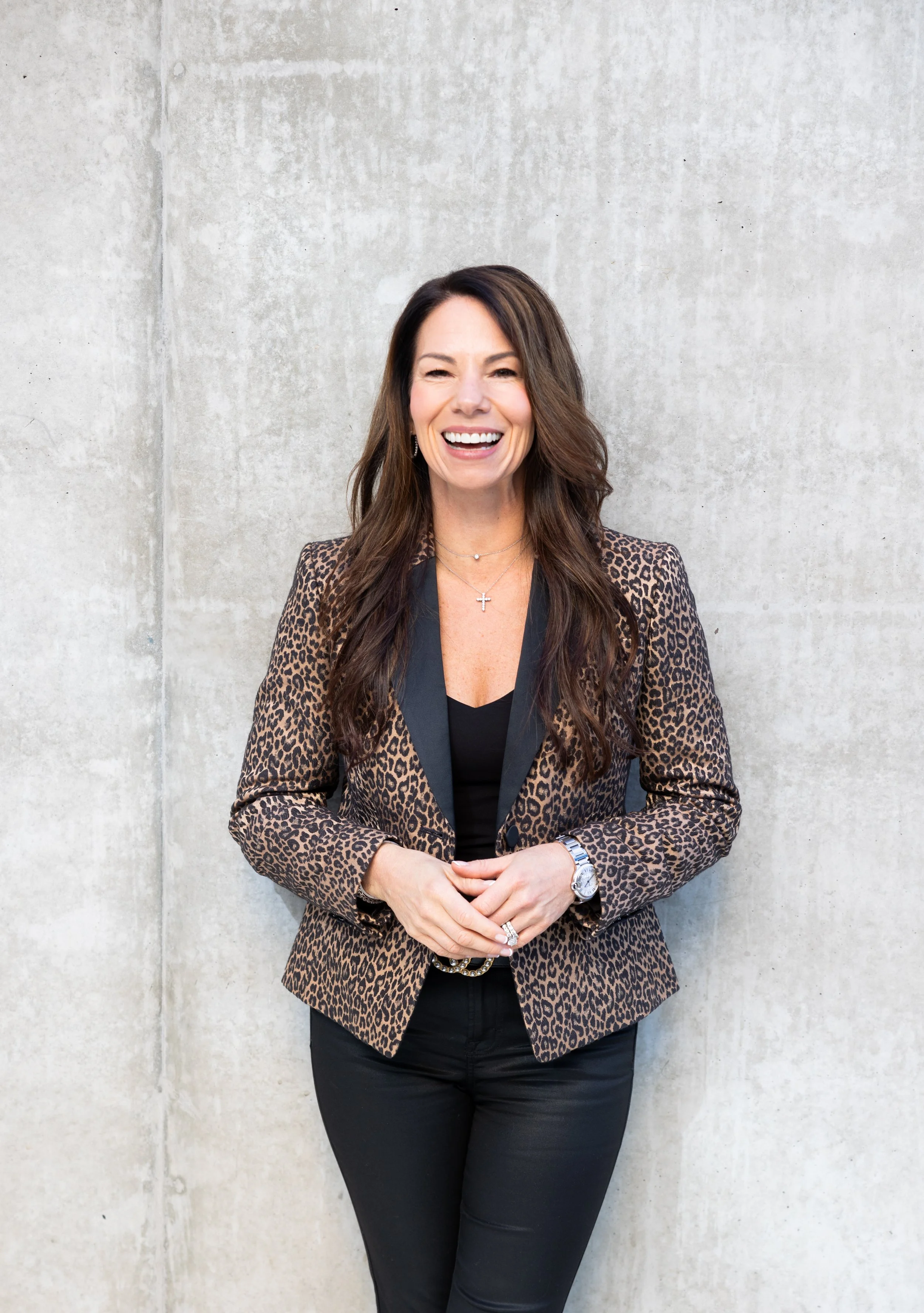 Tina Moore, standing and laughing,  offering guidance, support, love, and encouragement through alcohol recovery by creating spaces, tools, and rituals for other women.