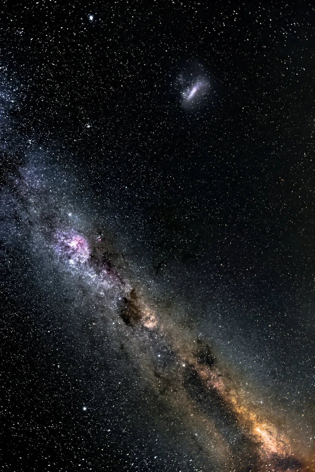 A view of the Milky Way galaxy with numerous stars, nebulae, and cosmic dust against a dark night sky.