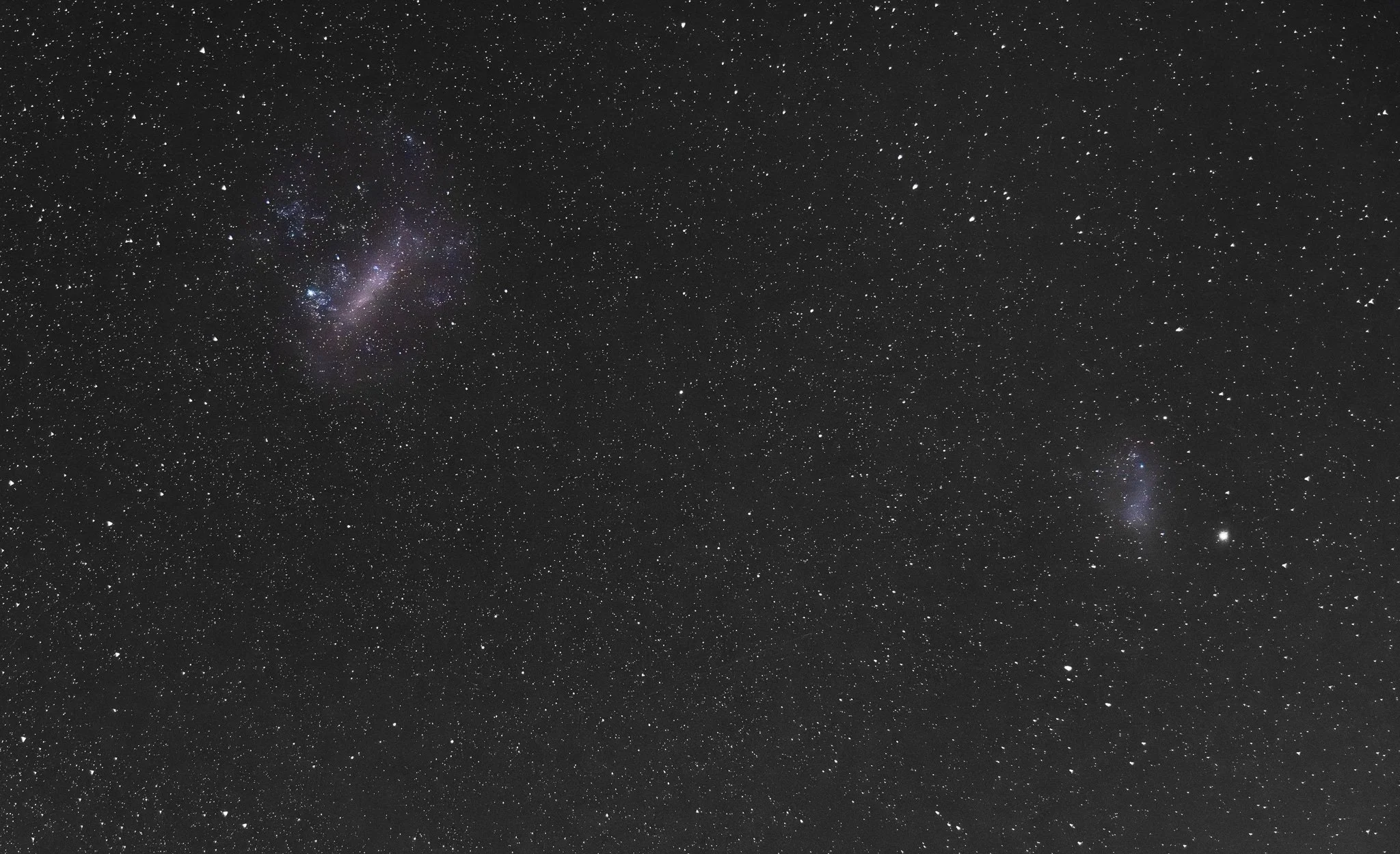 Starry night sky with numerous stars and a visible galaxy.