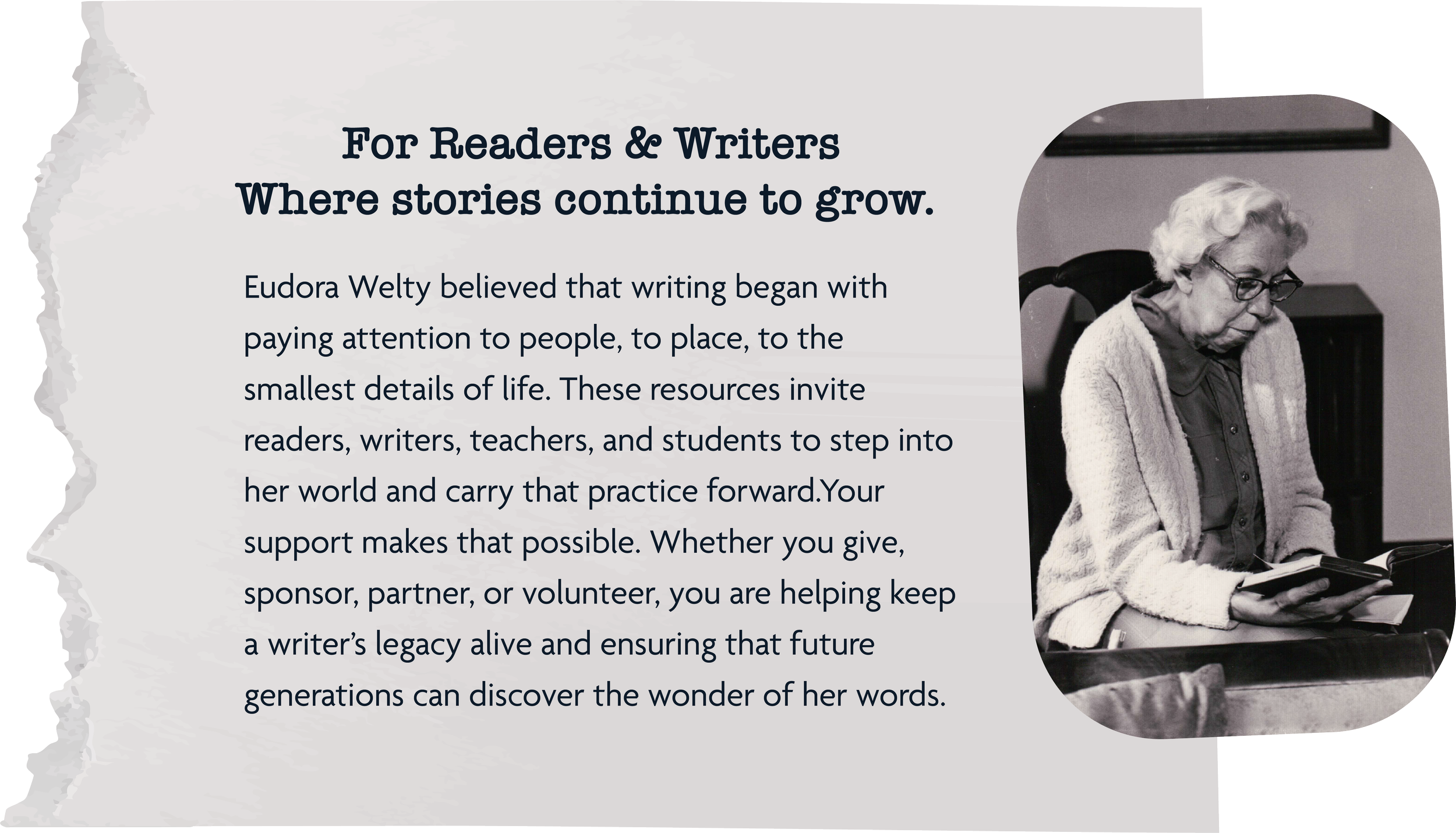 An elderly woman with white hair and glasses, wearing a cardigan over a dark shirt, sitting at a desk and reading a book in a room with framed artwork on the walls.