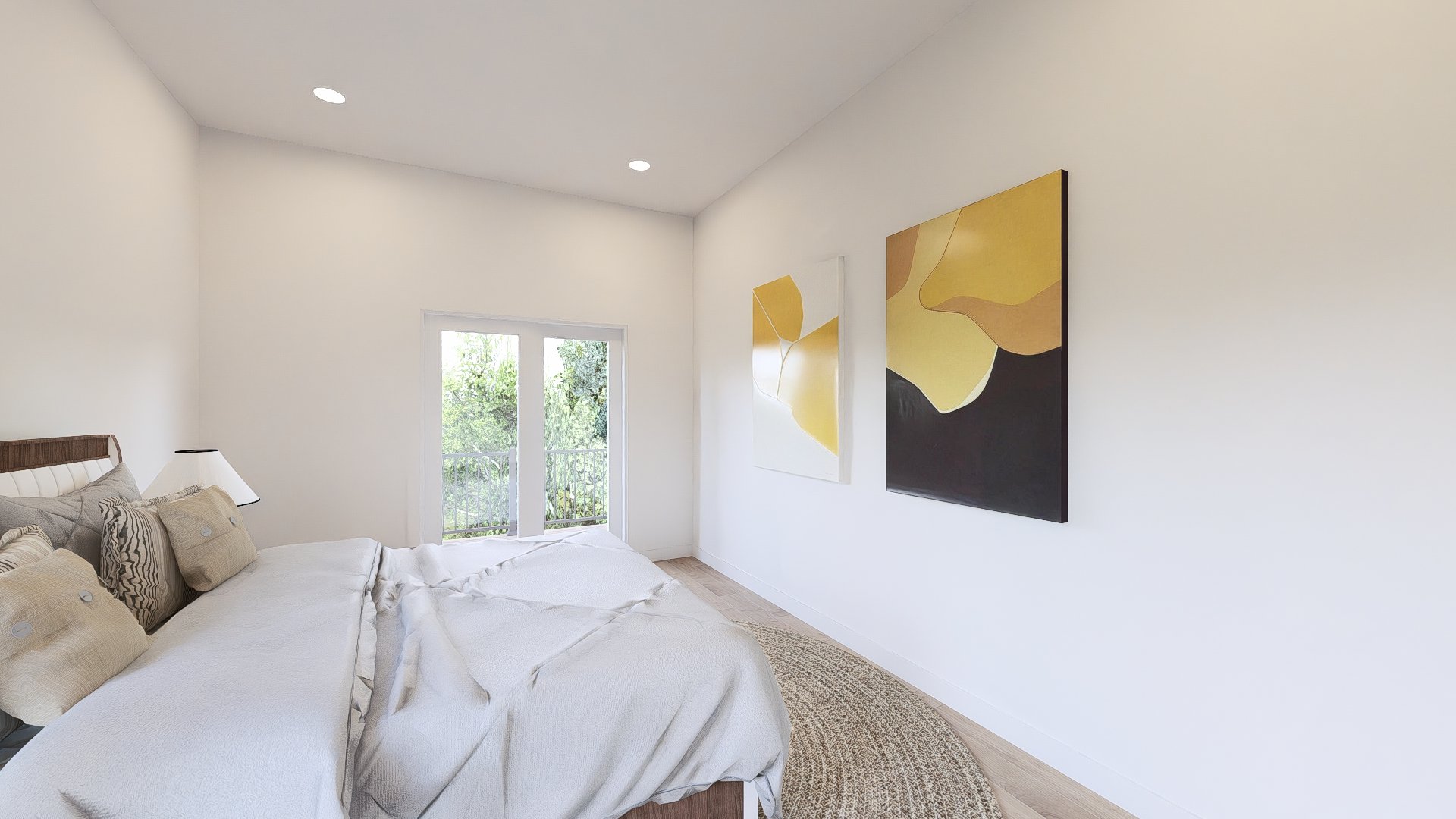 A bedroom with white walls, a bed with beige and patterned pillows, a bedside lamp, two abstract wall art pieces in yellow and black, and a sliding glass door leading to a balcony with greenery outside.