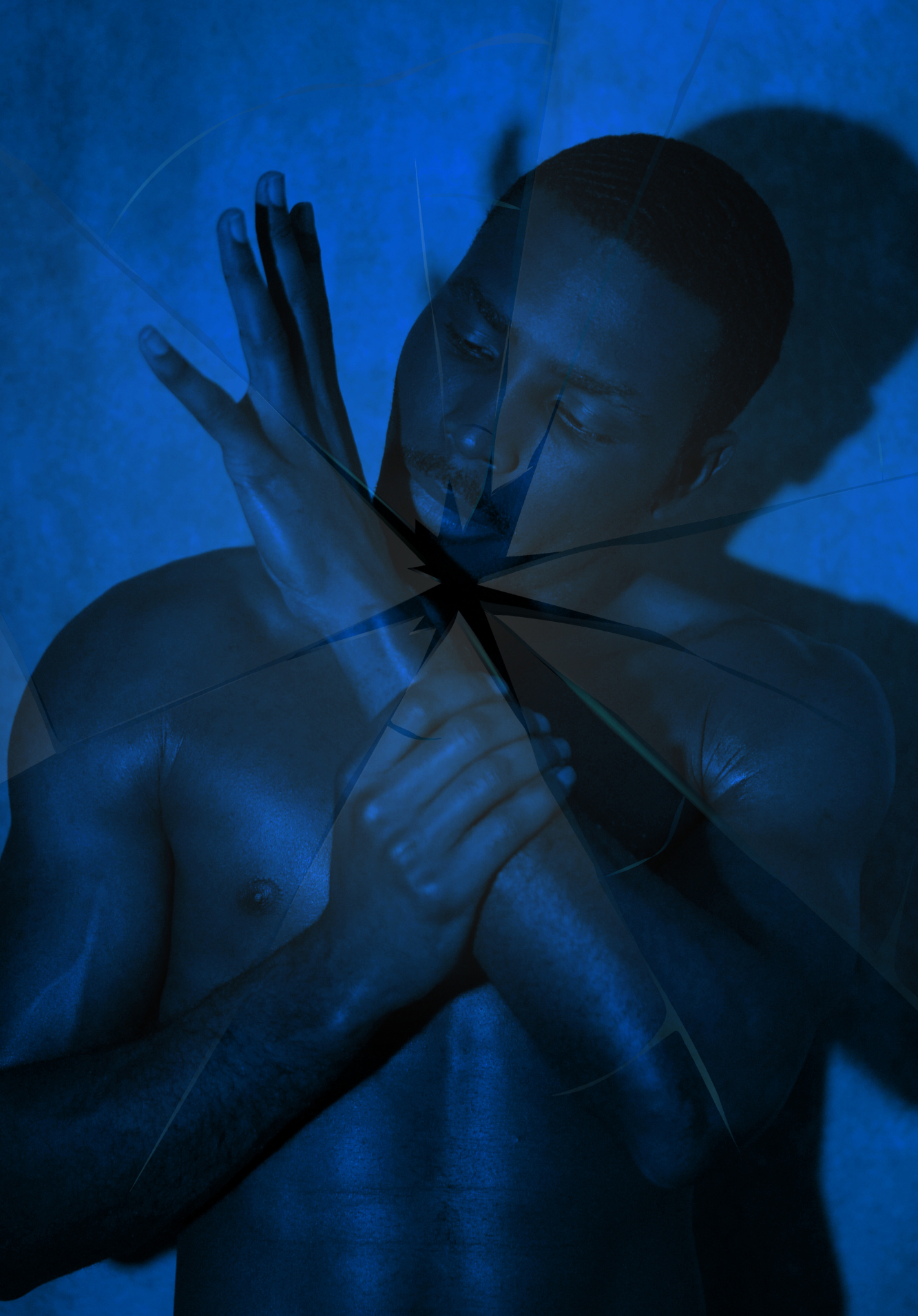 A shirtless man with short hair and a goatee looks at his hand, with a shattered glass effect overlay in blue tones creating a dramatic visual.