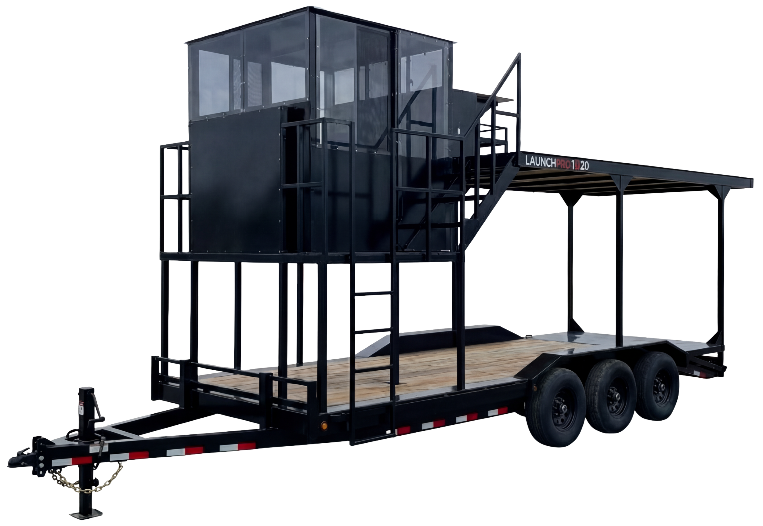 Black mobile stage trailer with a wooden floor, multiple wheels, and a large raised platform with a small enclosed glass cabin on top, used for launching fireworks or other displays.
