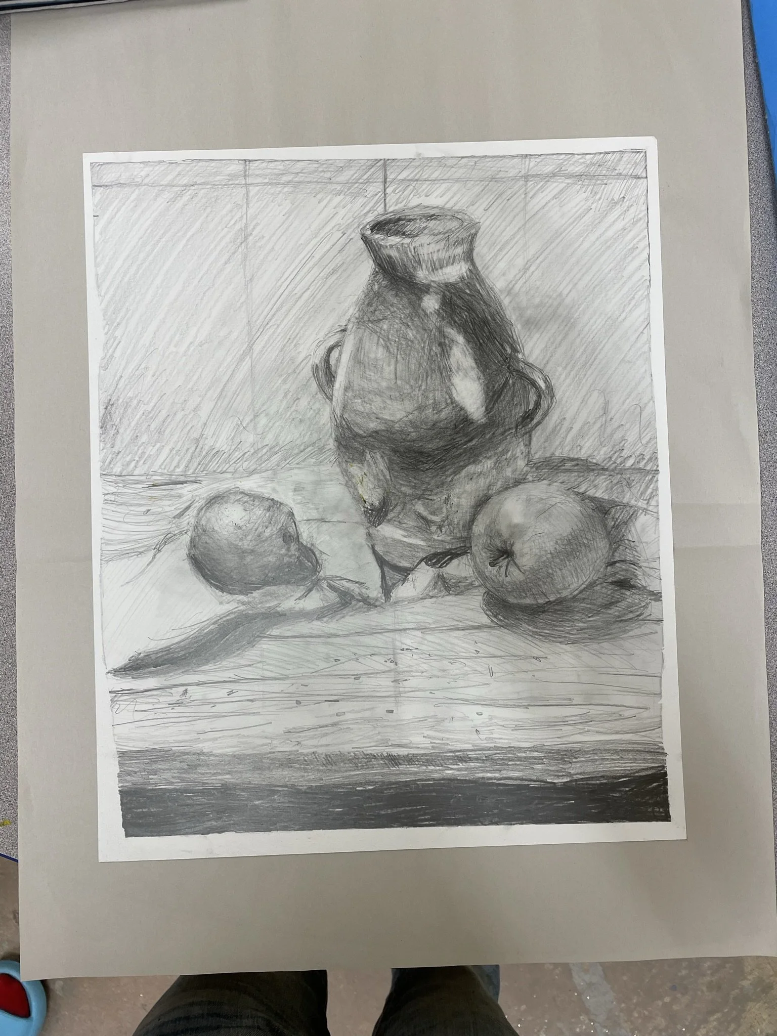 A pencil sketch of a still life scene with a tall vase, two apples, and a lemon on a table.