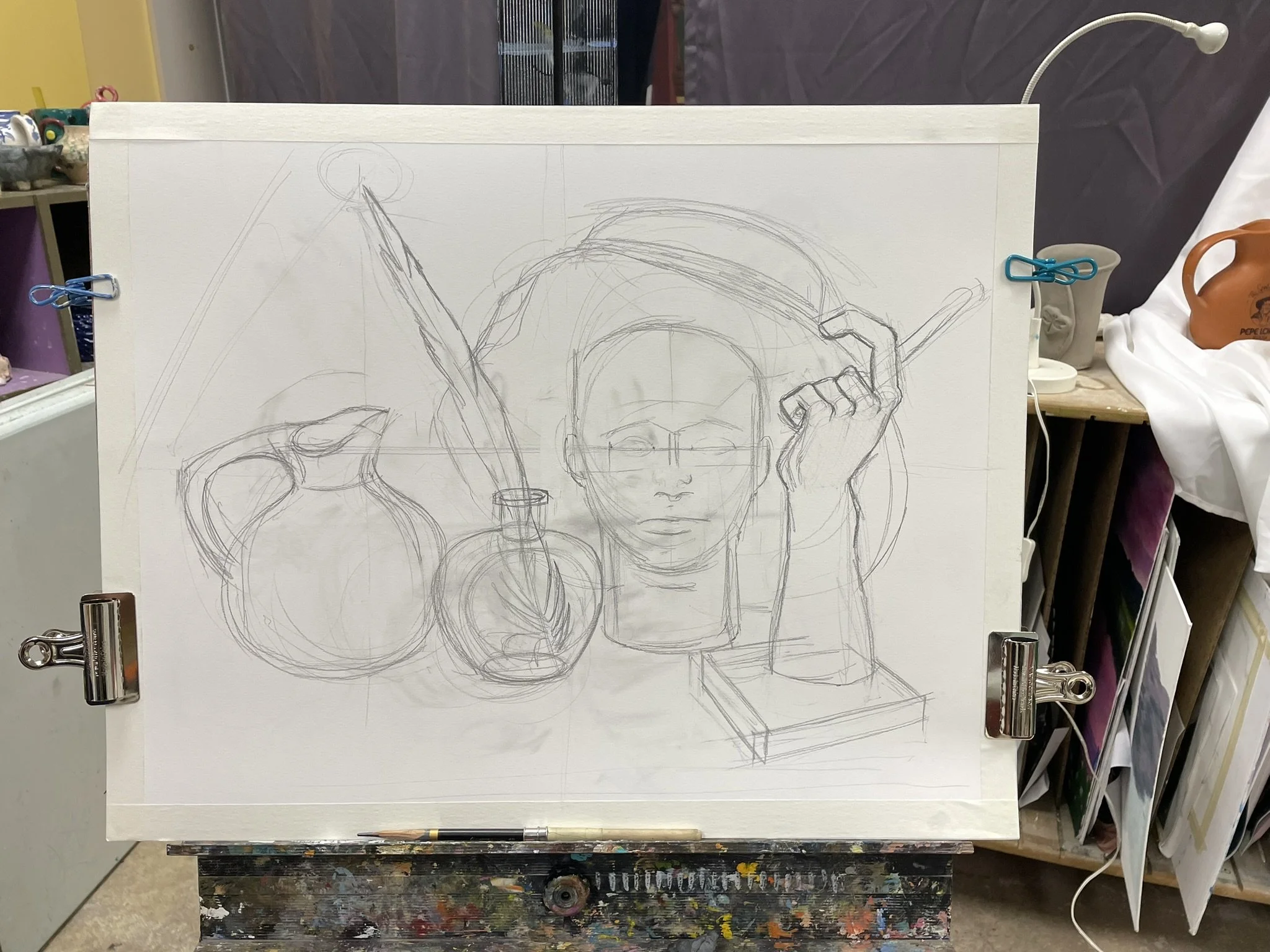 A pencil sketch of a still life scene with a human face, a flag, a pitcher, a vase, and a sculpture of a face on a rectangular base, all on a drawing board.