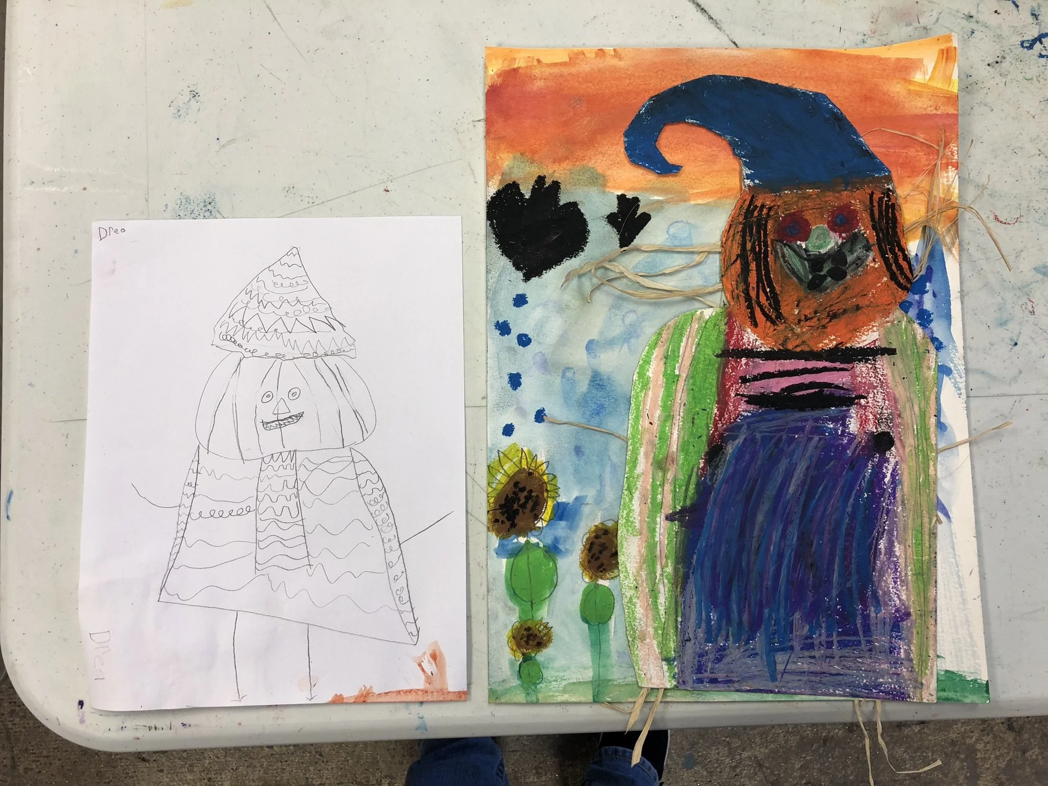 Children's artwork featuring a colorful painted figure with a blue hat, orange face, and green and pink clothing, standing against a vibrant background with flowers and sky.