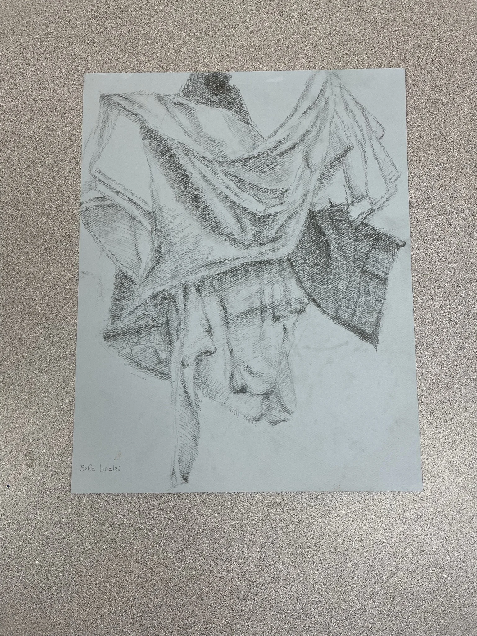 Pencil drawing of a person with a cloth draped over their head and shoulders, with their face partially visible, all in black and white.