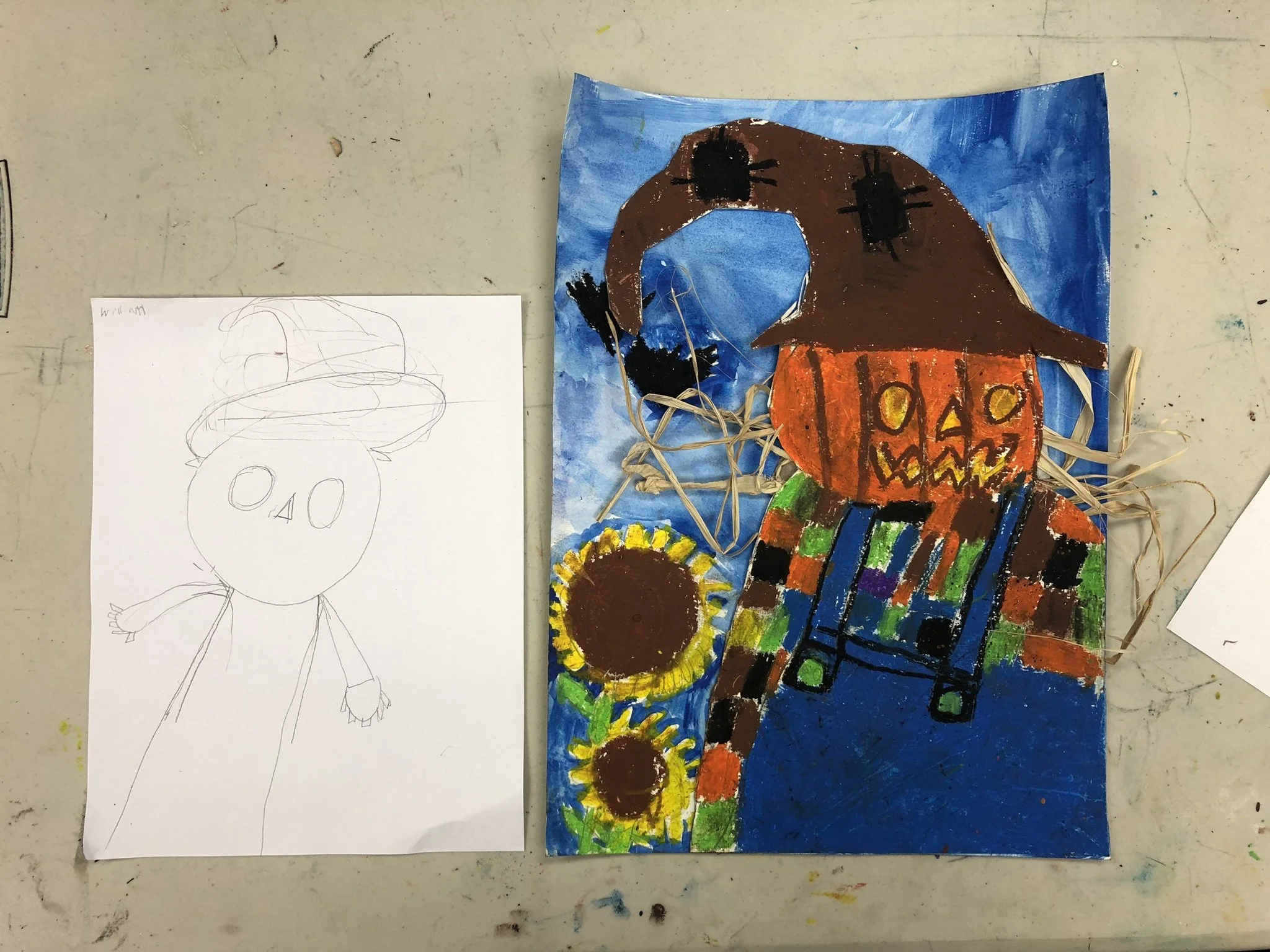 A colorful Halloween-themed artwork featuring a pumpkin-headed figure with a witch hat, painted on a decorated paper background with two sunflowers. Next to it is a simple pencil sketch of a similar pumpkin figure with a hat.