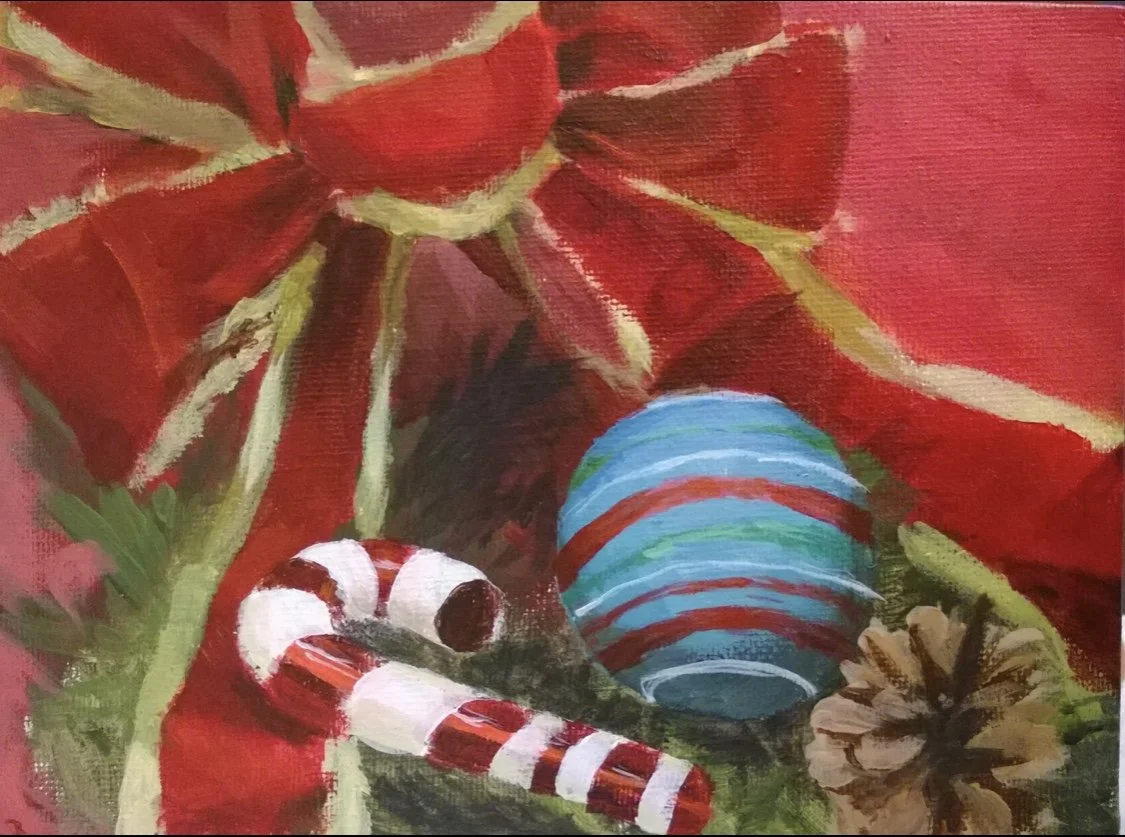 A decorated Christmas scene featuring a red poinsettia, a candy cane, a blue and red striped ornament, a pine cone, and green foliage.