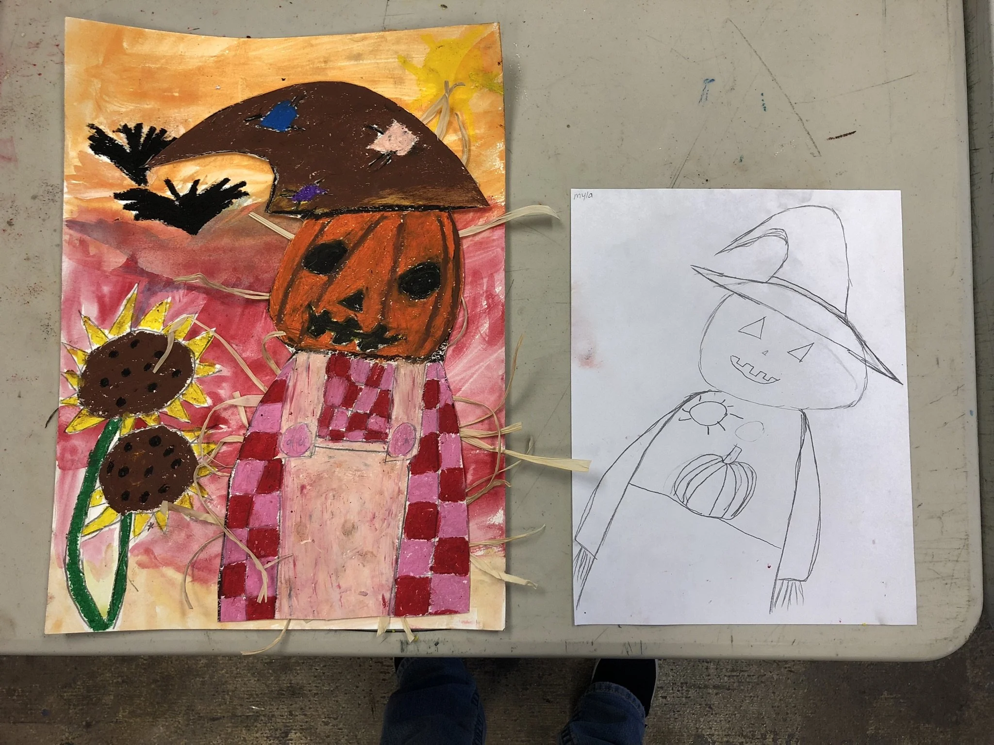 A colorful Halloween-themed artwork with a pumpkin-headed figure wearing a checkered pink and red apron, a large mushroom hat, and surrounded by sunflower plants, created with paint, paper, and strings. Next to it, a simple pencil sketch of the same 