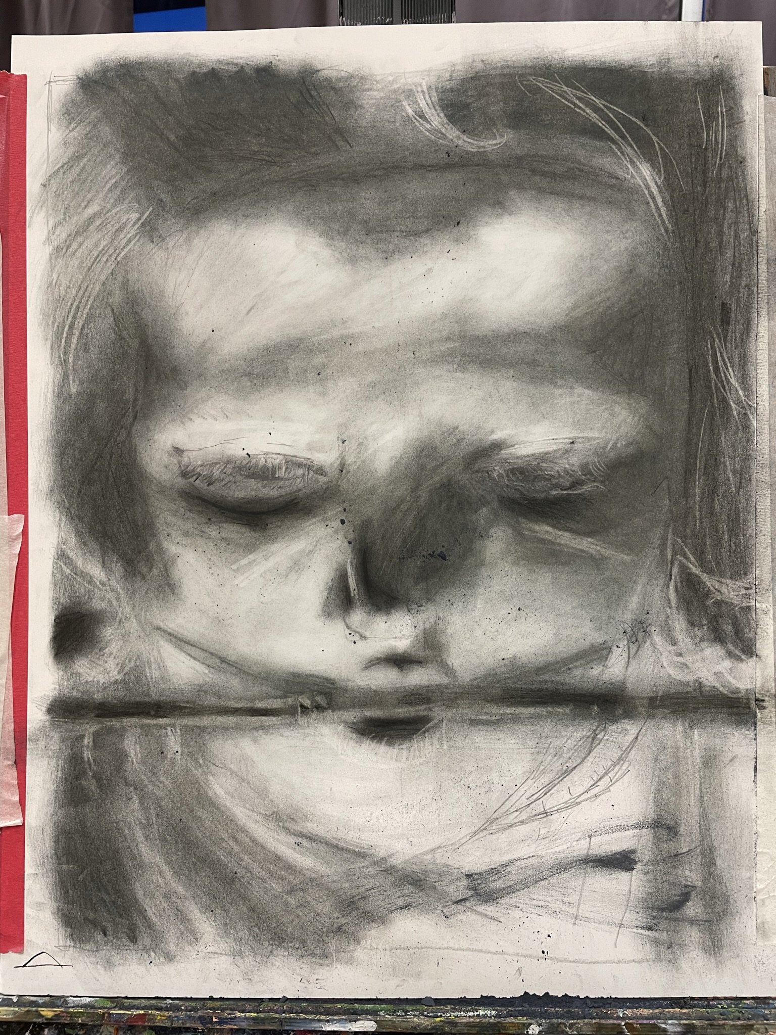 A black and white portrait of a person with closed eyes, with their reflection visible below, creating a mirror-like effect. The drawing emphasizes soft shading and delicate features.