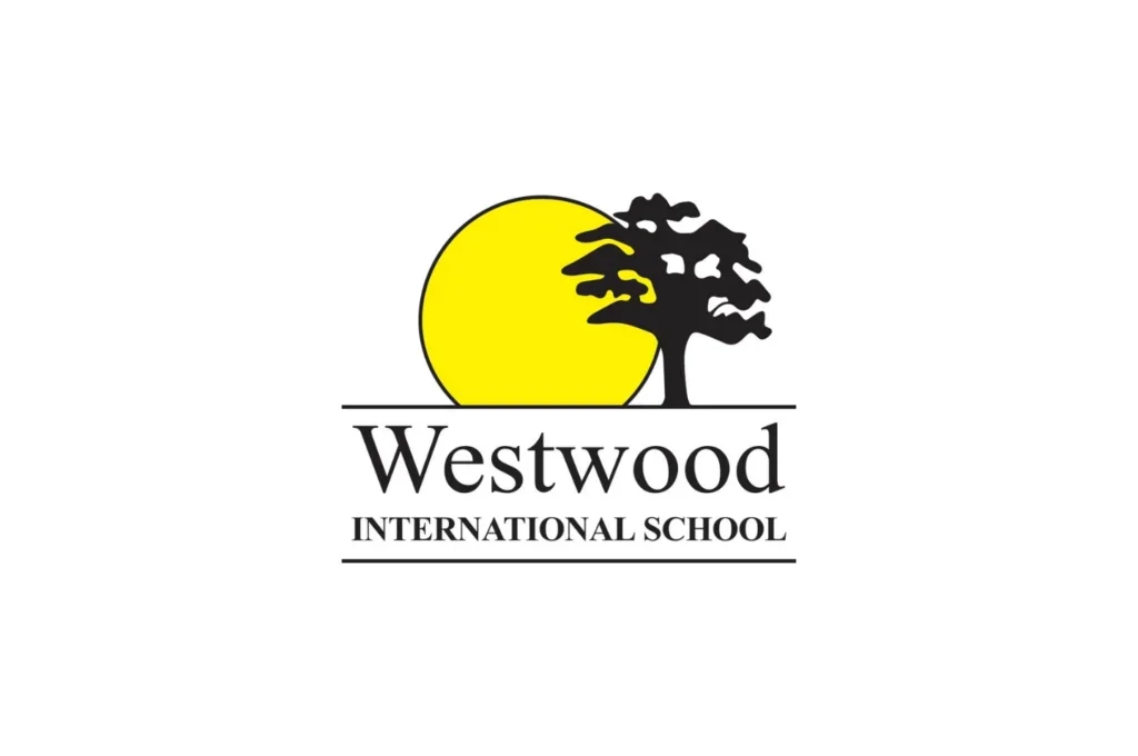 Logo of Westwood International School, featuring a yellow sun, a black tree, and the school name in black text.