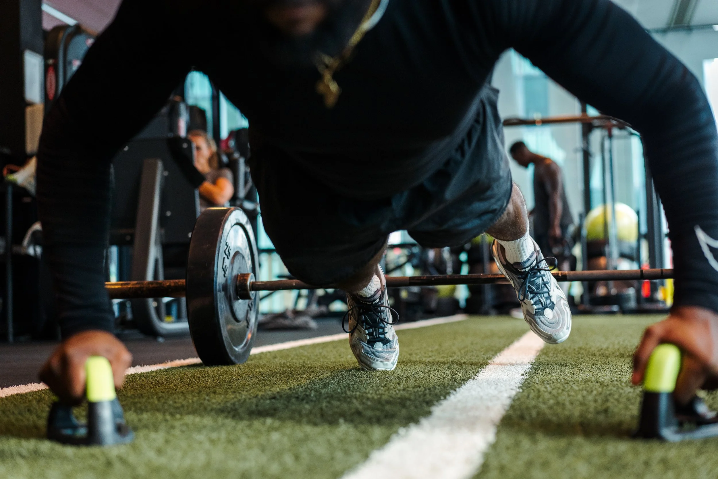 Man doing push-up with equipment in a gym.