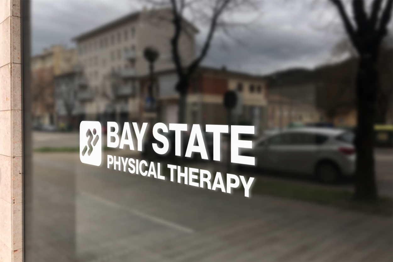 Sign for Bay State Physical Therapy on a glass window with a street scene reflection, including parked cars, trees, and buildings.