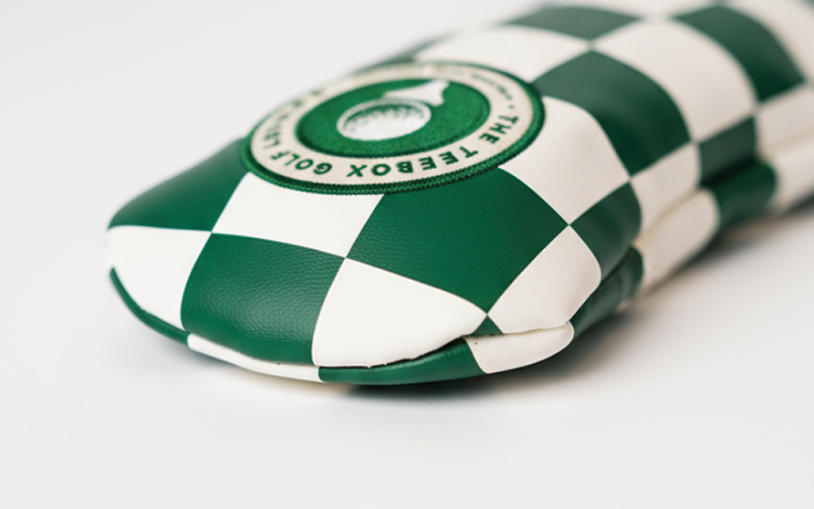 A green and white checkered wrapped package with a circular logo on top reading "The Telegraph Golf".
