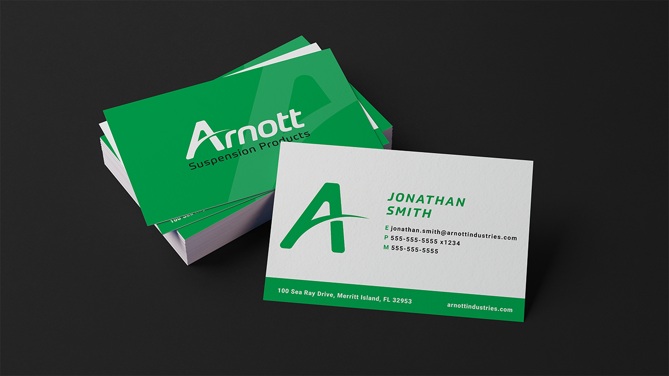 Business cards for Arnott Suspension Products, with one card showing contact information for Jonathan Smith, and a stack of green cards in the background.