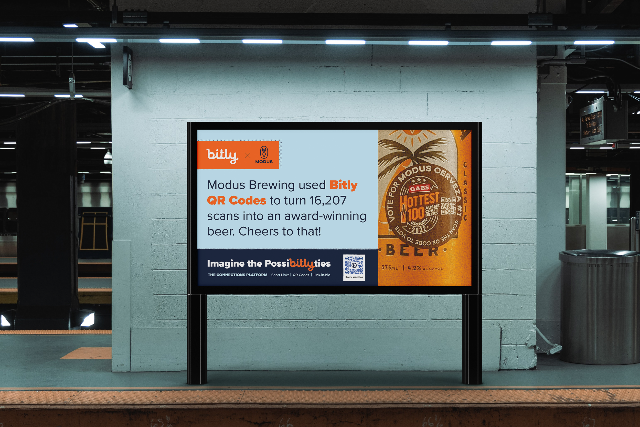 Digital advertisement display at a train station promoting QR code scanning for a beer award with a logo and some text.