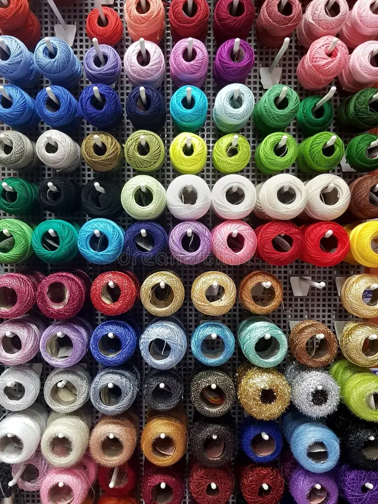 Colored spools of thread arranged on a display rack.