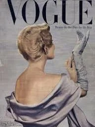 Cover of Vogue magazine featuring a woman with styled hair, wearing a dress with a strapless back, holding a mirror.