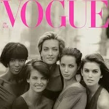 Black and white photo of five women posing together on the cover of Vogue magazine.