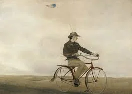 A person riding a vintage bicycle with a basket, wearing a hat and dark clothing, against a cloudy sky background.