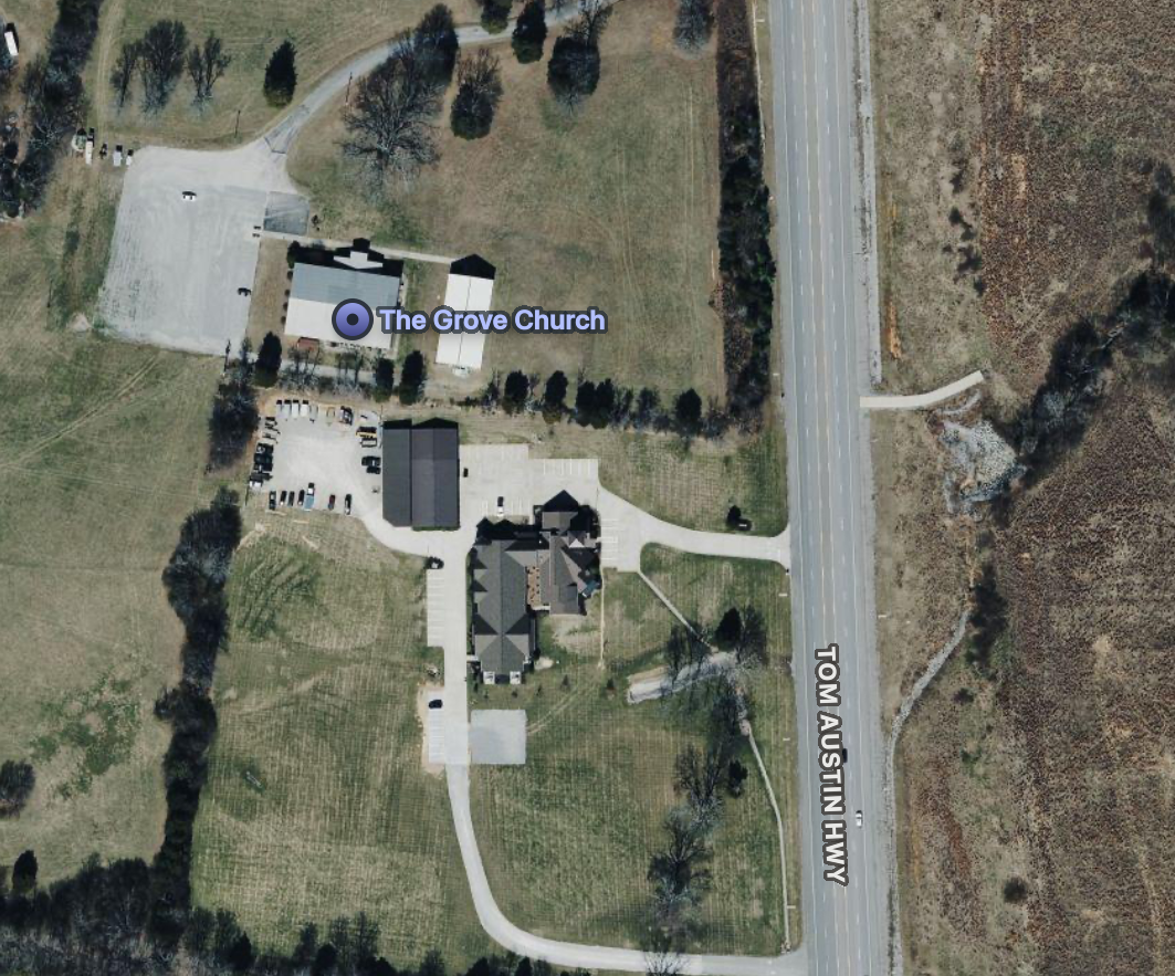 An aerial view of The Grove Church and surrounding area, including parking lots, nearby roads, and landscape.