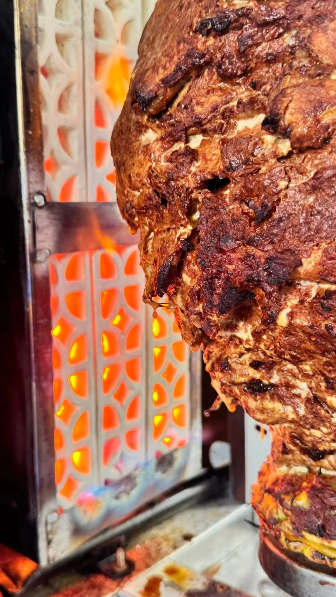 Carne asada en un espetón de comida callejera. 