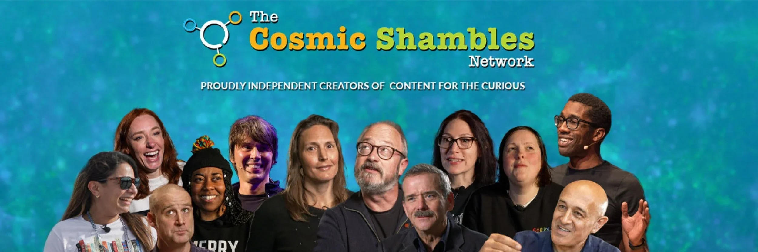 Group photo of diverse individuals standing in front of a blue-green background with the text 'The Cosmic Shambles Network' and 'Proudly independent creators of content for the curious'.