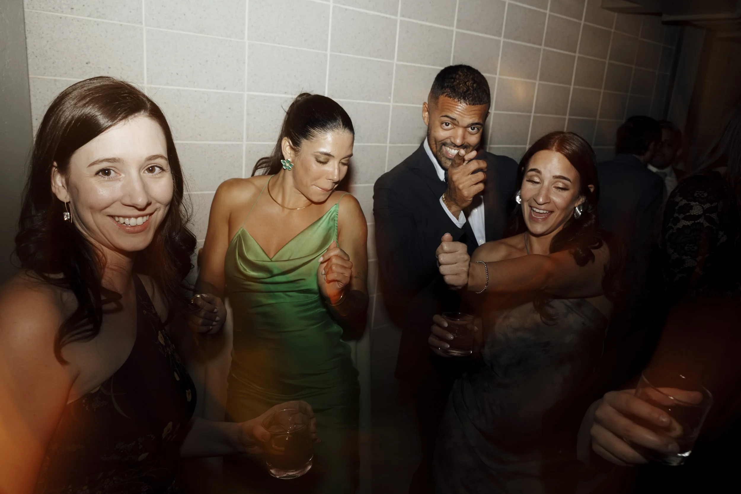 Group of people at an upstate NY wedding with drinks, smiling and enjoying the moment.