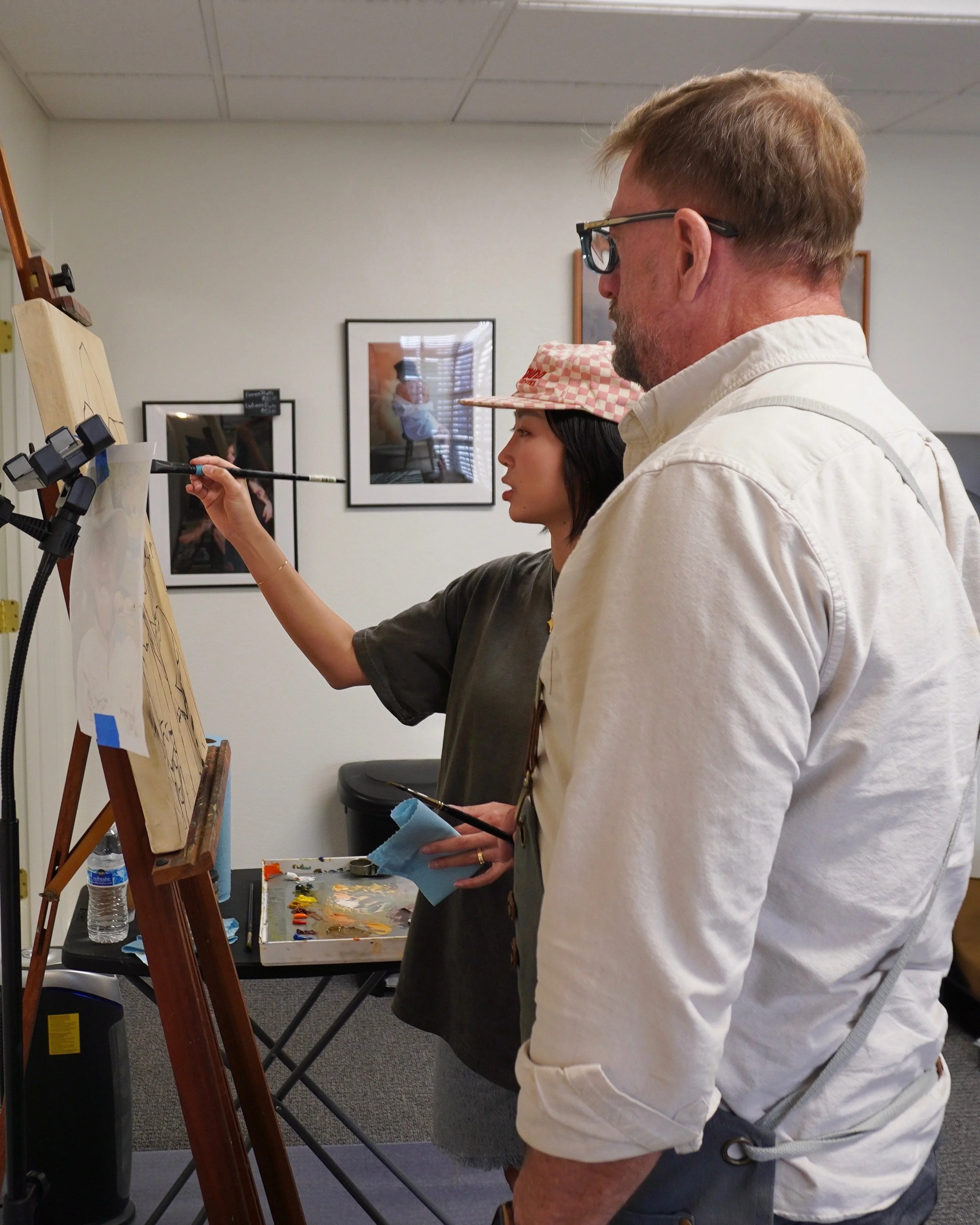 An instructor guiding a student at the easel at The Art Studio Eleven