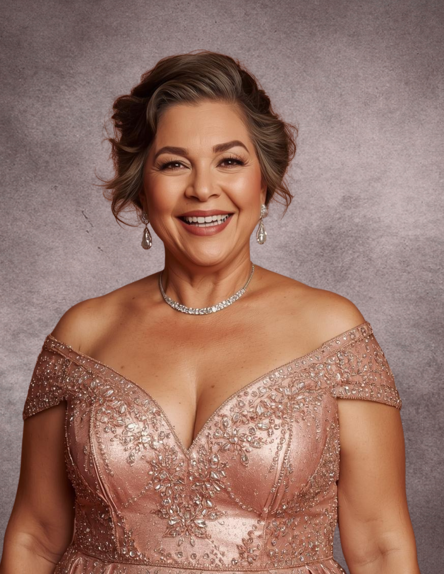 A smiling older woman with short, styled gray hair, wearing an off-the-shoulder, peach-colored gown embellished with gemstones, jewelry including earrings, a necklace, and a warm backdrop.
