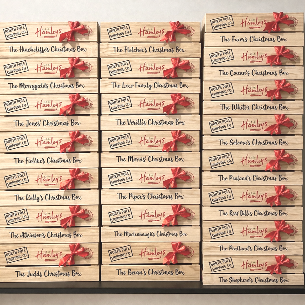 Stacked wooden Christmas boxes labeled with various themed names, decorated with red ribbons, arranged in columns.