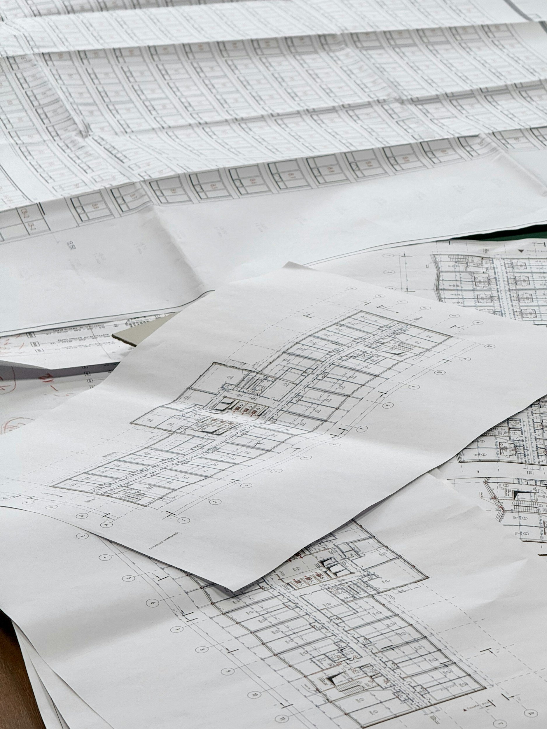 Architectural blueprints and floor plans scattered on a table.