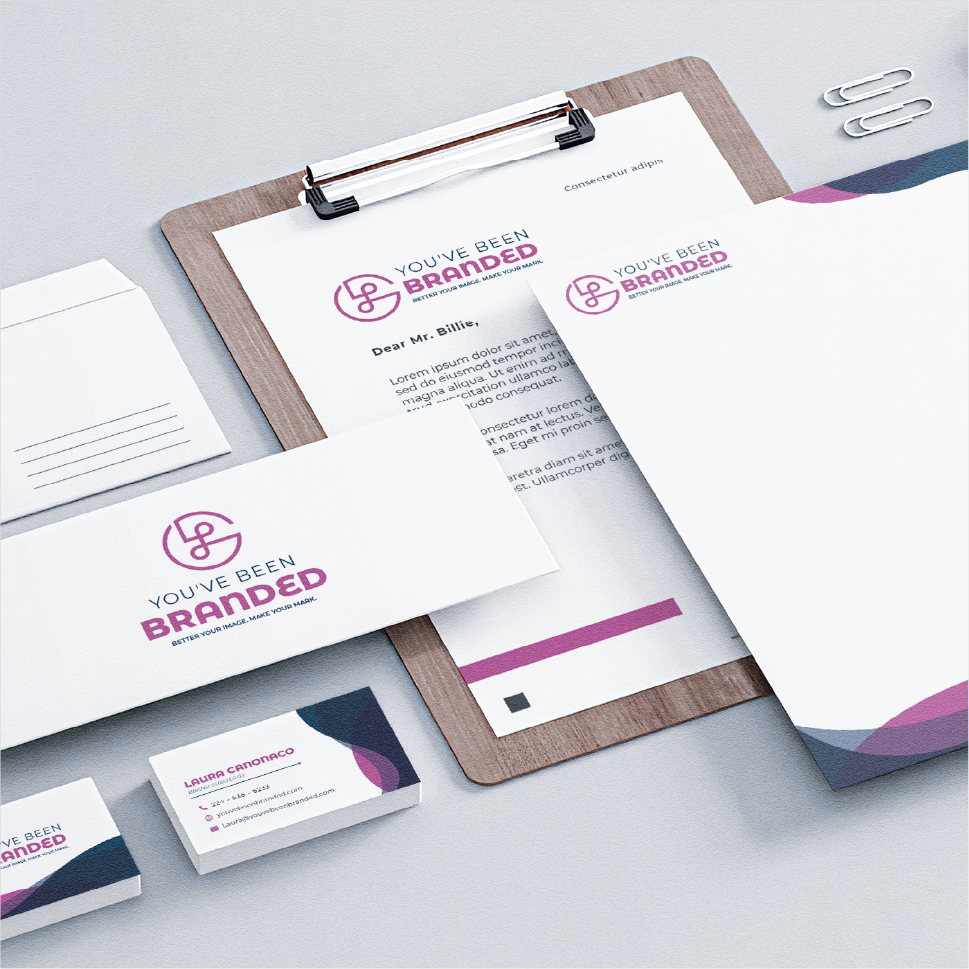 Branded stationery set including letterhead, envelope, business cards, and paper clips on a light gray surface.